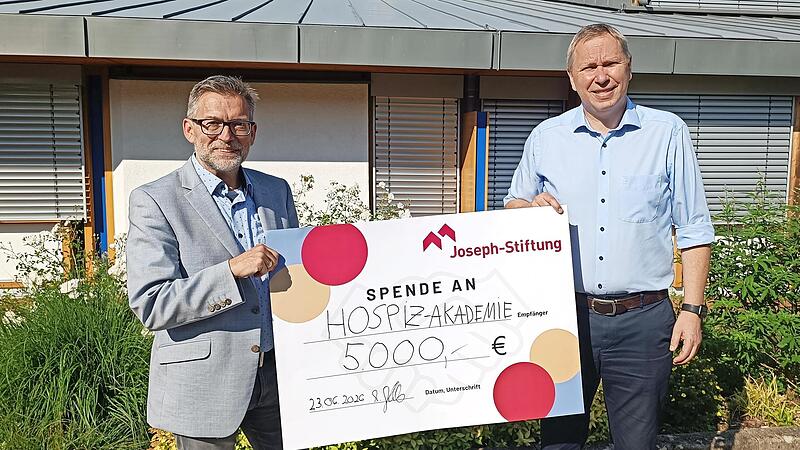 Markus Jakob, Vorstand der Joseph-Stiftung (rechts), &uuml;bergibt symbolisch einen Scheck &uuml;ber 5000 Euro an Markus Starklauf, Leiter der Hospiz-Akademie Bamberg.