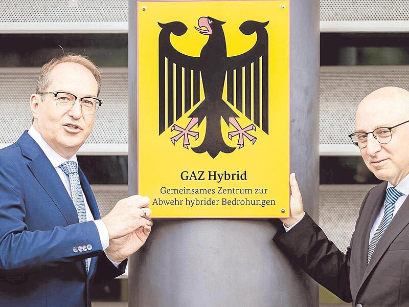 Bundesinnenminister Alexander Dobrindt (links) bringt mit Verfassungsschutzchef Sinan Selen zur Einweihung des Zentrums zur Abwehr hybrider Bedrohungen das Amtsschild an. Bundesinnenminister Alexander Dobrindt (links) bringt mit Verfassungsschutzchef Sinan Selen zur Einweihung des Zentrums zur Abwehr hybrider Bedrohungen das Amtsschild an.