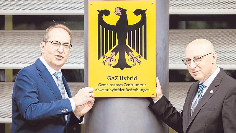 Bundesinnenminister Alexander Dobrindt (links) bringt mit Verfassungsschutzchef Sinan Selen zur Einweihung des Zentrums zur Abwehr hybrider Bedrohungen das Amtsschild an. Bundesinnenminister Alexander Dobrindt (links) bringt mit Verfassungsschutzchef Sinan Selen zur Einweihung des Zentrums zur Abwehr hybrider Bedrohungen das Amtsschild an.