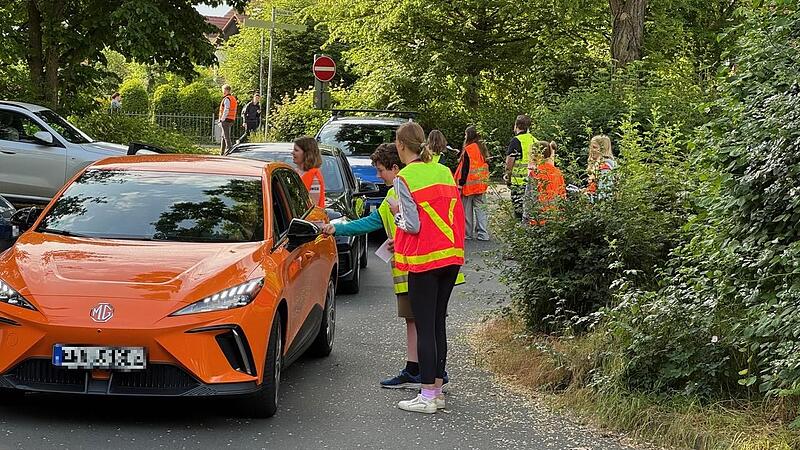 Sch&uuml;ler sprechen in Herzogenaurach Eltern in den Fahrzeugen an.