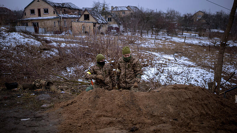 Ukrainische Soldaten beziehen Stellung in einem Schützengraben am Stadtrand.