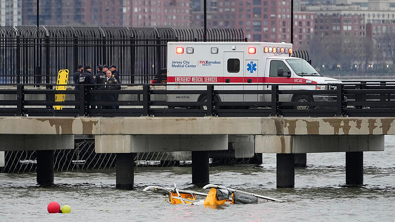 10.04.2025, USA, Jersey City: Ersthelfer stehen in Jersey City, New Jersey, an der Stelle, an der ein Hubschrauber in den Hudson River gest&uuml;rzt ist, auf einem Pier in Jersey City, New Jersey.