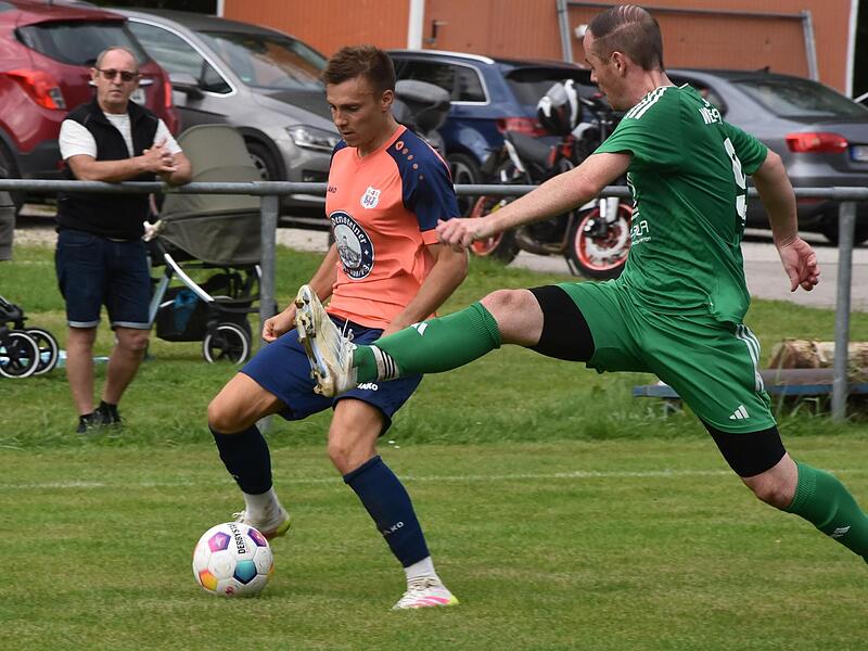 Geschwands Nikolai Reichel sucht die Lücke, doch Gästeverteidiger Adrian Bayerlein (grün) springt in die Parade.Forchheim & Fränkische Schweiz