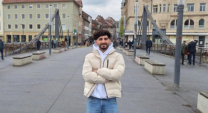 Omar Ramadhan im April 2024 auf der Kettenbr&uuml;cke in Bamberg. Der Iraker hofft, dass er bald seine Ausbildung zum Medizinischen Fachangestellten starten darf.