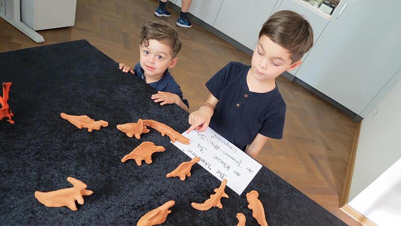 Mateo und Lias begutachten  die Urzeittiere aus Ton.