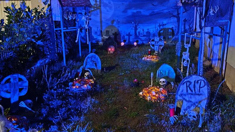 Halloween-Haus in Volkach: Bei Nacht sieht alles noch gruseliger aus. Neben dem Haus gr&uuml;&szlig;en Plastik-Skelette vom "Friedhof".