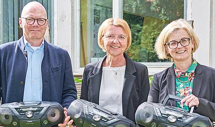 Stefan Echinger, Administrativer Direktor LIfBi (l.), &uuml;berreichte gemeinsam mit Bildungsreferentin Gabriele Kepic (r.) f&uuml;nf CD-Player an die Schulleiterin der Erl&ouml;ser-Mittelschule, Elke Barth.