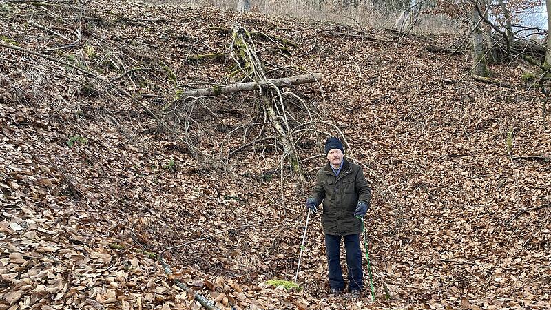 Einer der tiefen Bombenkrater ist am Hang des Spitzbergs heute noch auszumachen, wie Reinhard Bauerfeind demonstriert.