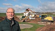 B&uuml;rgermeister Peter Bergel an der Baustelle: Im Hintergrund wird aktuell das Geb&auml;ude abgerissen, im Bereich rechts vorne beginnen bald die Arbeiten f&uuml;r den Netto-Markt.
