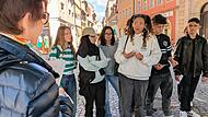 Schülerinnen und Schüler der 10. Klasse der Hugo-von-Trimberg-Schule in Bamberg diskutieren mit Christa Reich über Kosumentscheidungen.