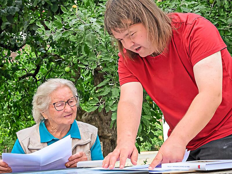 Namen, Orte und Jahreszahlen werden zu Familiengeschichte: Christian Zametzer erkl&auml;rt Rosa Schmitt aus Baad, wie sich ihre v&auml;terliche Linie von Wimmelbach &uuml;ber Hausen und Elsenberg bis nach Baad verfolgen l&auml;sst.
