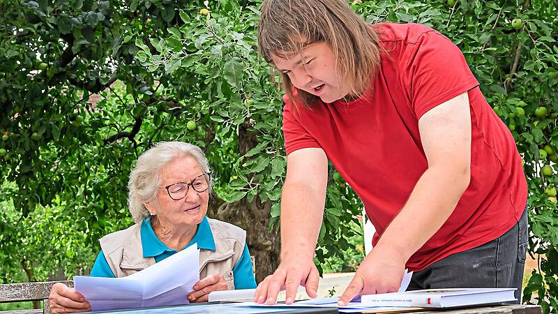 Namen, Orte und Jahreszahlen werden zu Familiengeschichte: Christian Zametzer erkl&auml;rt Rosa Schmitt aus Baad, wie sich ihre v&auml;terliche Linie von Wimmelbach &uuml;ber Hausen und Elsenberg bis nach Baad verfolgen l&auml;sst.