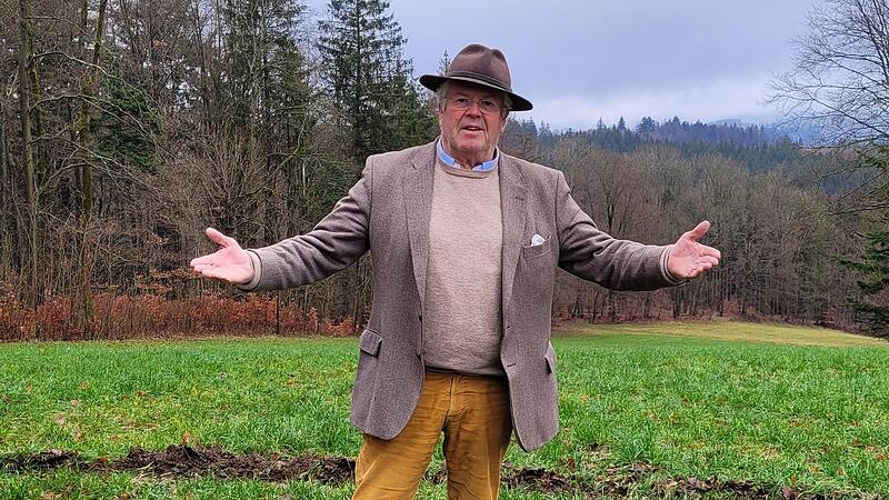 Liftbetreiber Ludwig Freiherr von Lerchenfeld vor der grünen Wiese, auf der sich normalerweise die Skipiste befindet.