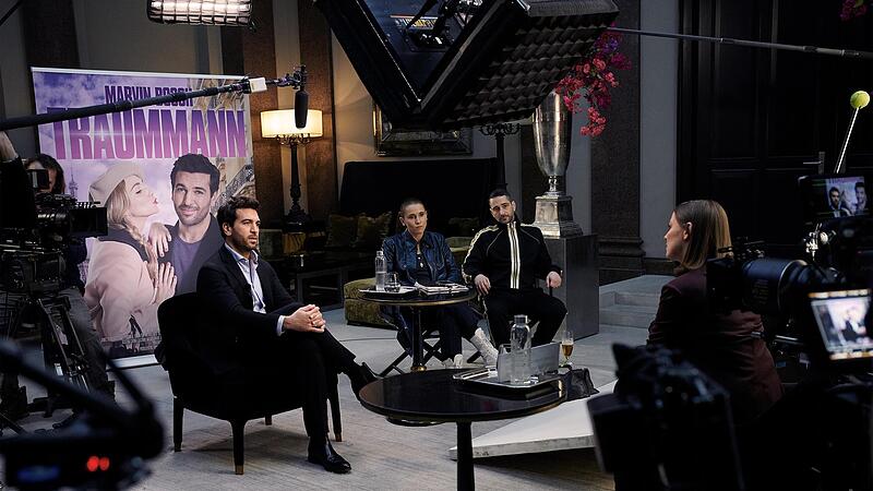 Marvin (Elyas M&rsquo;Barek, links) wird von Boulevardjournalistin Bettina Bamberger (Alexandra Maria Lara, rechts) interviewt. Seine Freunde Sammy (Peri Baumeister) und Hakan (Denis Moschitto) sind skeptisch.