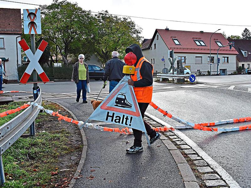 Diese Situation ist derzeit stündlich in Igensdorf zu erleben. Bahnpersonal sichert den Bahnübergang mit Absperrbändern über die Straße. Petra Malbrich Diese Situation ist derzeit stündlich in Igensdorf zu erleben. Bahnpersonal sichert den Bahnübergang mit Absperrbändern über die Straße. Petra Malbrich
