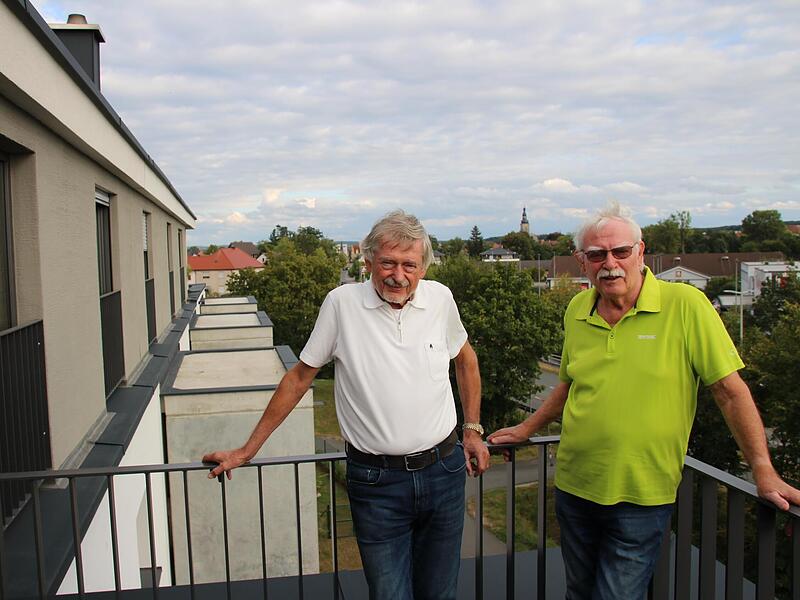 Johann Ettl (links) und Reinhard Grasse z&auml;hlen zu den Gr&uuml;nderv&auml;tern der Wohnungsbaugenossenschaft Aischgrund. Sie wohnen im ersten Projekt der Genossenschaft und genie&szlig;en vom Balkon ihrer Wohnungen den Blick &uuml;ber den Aischgrund.