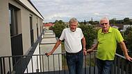 Johann Ettl (links) und Reinhard Grasse zählen zu den Gründervätern der Wohnungsbaugenossenschaft Aischgrund. Sie wohnen im ersten Projekt der Genossenschaft und genießen vom Balkon ihrer Wohnungen den Blick über den Aischgrund.
