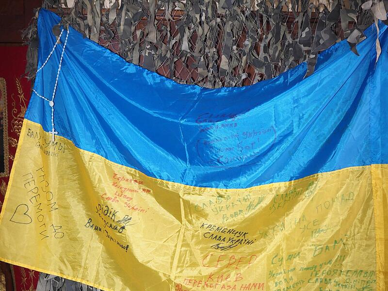 Geld und Sachspenden f&uuml;r die Menschen und die Soldaten in der Ukraine sammelt die orthodoxe Gemeinde. In der Kapelle h&auml;ngen auch eine Nationalflagge und ein Tarnnetz.