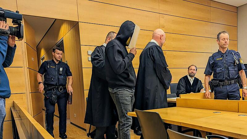 Auf dem Weg zur Anklagebank: Mit Fu&szlig;fessel ist der 22-j&auml;hrige Beschuldigte (Mitte) am Montag in den Gerichtssaal des W&uuml;rzburger Landgerichts gef&uuml;hrt worden.