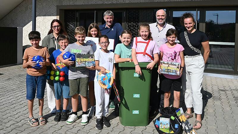 Sportbeauftragte Christiane Kn&ouml;tgen-Runtsch, AOK-Teamleiter Stephan G&ouml;tz, Schulleiter Thomas Riehle und die Elternbeiratsvertreterin Veronika Druckenbrod freuen sich mit den Sch&uuml;lerinnen und Sch&uuml;lern der Grund- und Mittelschule Volkach &uuml;ber die neuen Spielger&auml;te f&uuml;r die Pause.