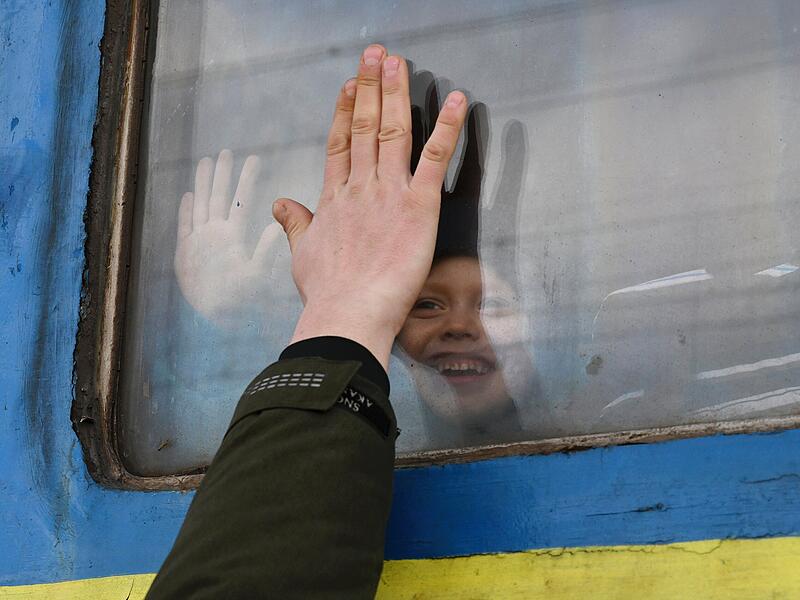 Ein Kind, das aus dem Fenster eines Zugwaggons in Kramatorsk schaut, während es auf die Abfahrt in Richtung Westukraine wartet, verabschiedet sich von einem Verwandten. Wegen des russischen Angriffs auf die Ukraine sind nach Angaben des UN-Flüchtlingshilfswerks (UNHCR) etwa 368 000 Menschen auf der Flucht.