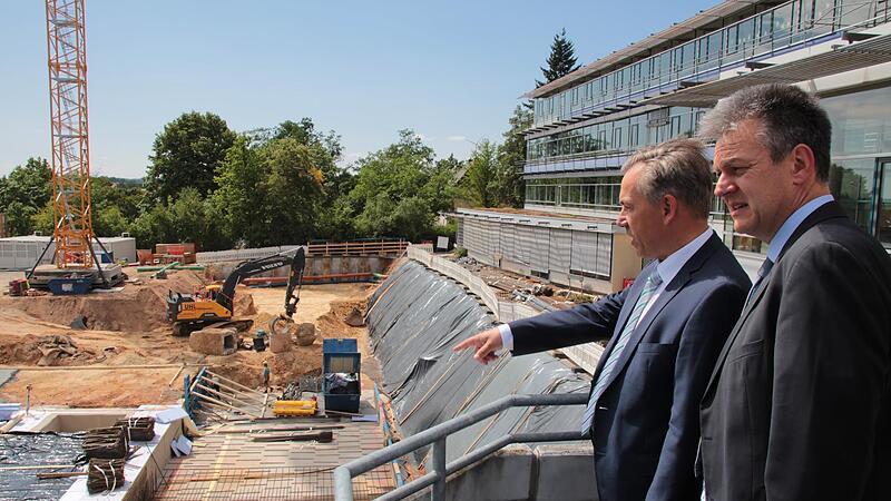 Landrat Alexander Tritthart (links) und der neue Leiter des H&ouml;chstadter Gymnasiums, Alois Selder, werfen einen Blick auf die Grube f&uuml;r den Erweiterungsbau.