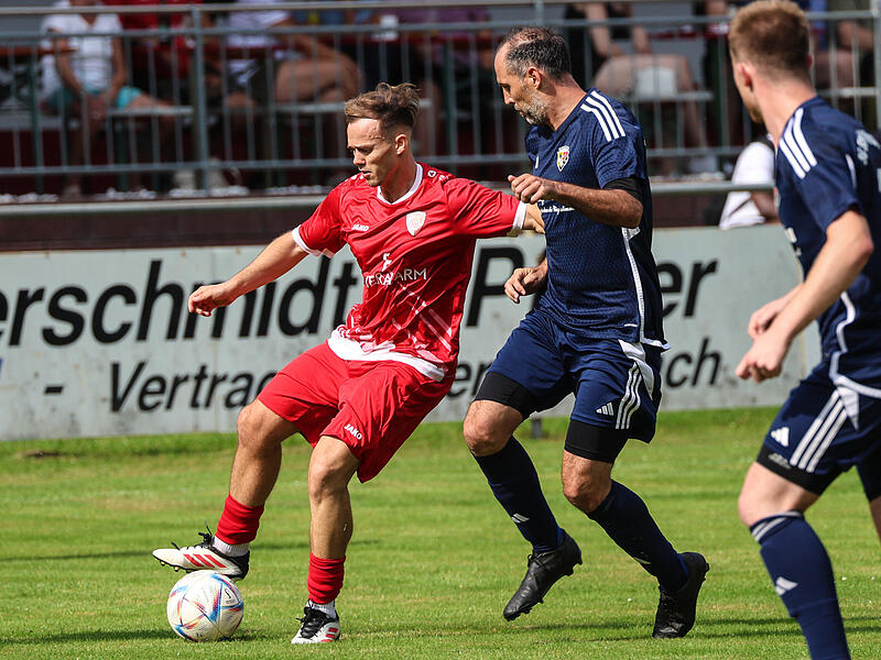Im Mittelfeld versucht Steinbachs Bastian Renk (blau) das Aufbauspiel von Kronachs Spielertrainer  Alexander Kunz zu stören.