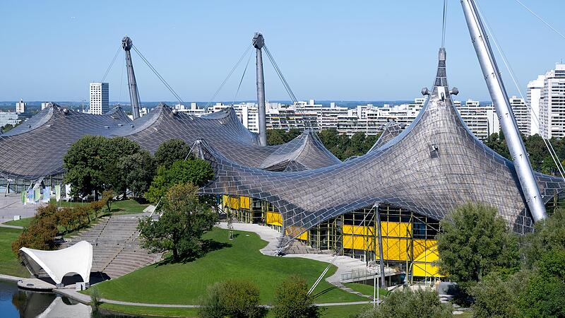 Die Olympiahalle (l) und die Schwimmhalle der olympischen Sommerspiele von 1972 sind im Olympiapark zu sehen. Am 26. Oktober 2025 findet der Bürgerentscheid zur Bewerbung der Stadt München um Olympische und Paralympische Spiele statt.