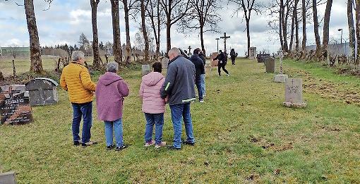 Besucher am Friedhof Reu&szlig;endorf. Am rechten Rand erkennt man Sch&auml;den, die Wildschweine angerichtet haben.