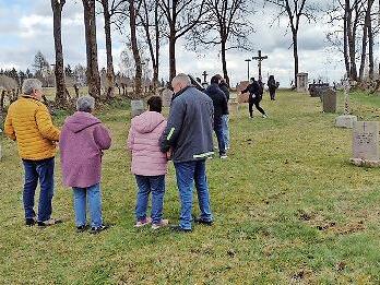 Besucher am Friedhof Reu&szlig;endorf. Am rechten Rand erkennt man Sch&auml;den, die Wildschweine angerichtet haben.