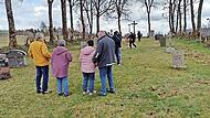 Besucher am Friedhof Reu&szlig;endorf. Am rechten Rand erkennt man Sch&auml;den, die Wildschweine angerichtet haben.