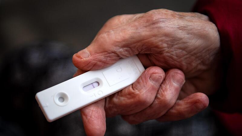 23.11.2021, Bremen: Eine Seniorin h&auml;lt einen Corona-Schnelltest in der Hand.