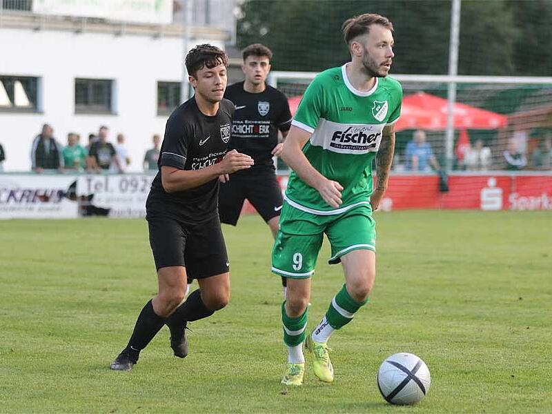 St&uuml;rmer Max Sch&uuml;lein vom SV Friesen (gr&uuml;n) ist  hier in einem Derby gegen seinen Noch-Konkurrenten TSV Neukenroth zu sehen. Nach der laufenden Saison wechselt er  an die Neukenrother Ochsenwiese.