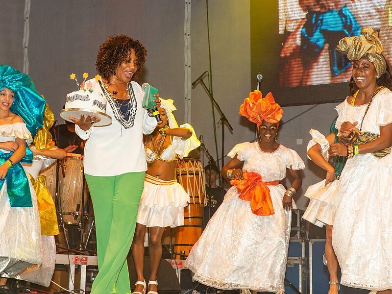 2018 trat Margareth Menezes (gr&uuml;ne Hose) beim Samba-Festival in Coburg auf. Nini Beyersdorf (rechts) &uuml;berreichte ihr eine Torte zum B&uuml;hnenjubil&auml;um.