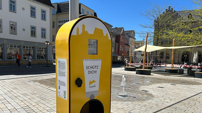 In diesem Spender auf dem Albertsplatz befindet sich Sonnencreme mit dem Lichtschutzfaktor 50 plus; &uuml;ber s&auml;mtliche Inhaltsstoffe kl&auml;rt ein Hinweisschild auf. Im Hintergrund ist das neue Sonnensegel zu sehen.