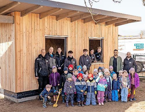 Das Bau-Team von Hanse Haus, Yanik Berberich (Leiter der KiTa St. Anna in Schondra) und die Kinderschar freuen sich &uuml;ber das neue Ger&auml;tehaus.