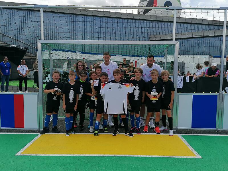 Die Kids des ASV Niederndorf mit Nico Schlotterbeck und DFB-Co-Trainer Mads Buttgereit (hinten re.). Die Kids des ASV Niederndorf mit Nico Schlotterbeck und DFB-Co-Trainer Mads Buttgereit (hinten re.).
