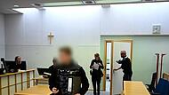 Der Angeklagte wird von zwei Polizeibeamten in den Saal des Amtsgerichts Bamberg geführt. Er überfiel kurz nach Silvester seinen Dealer.