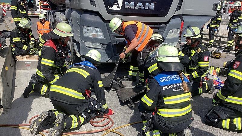 Feuerwehrleute bergen verletzte Frau unter Lastwagen Feuerwehrleute bergen verletzte Frau unter Lastwagen