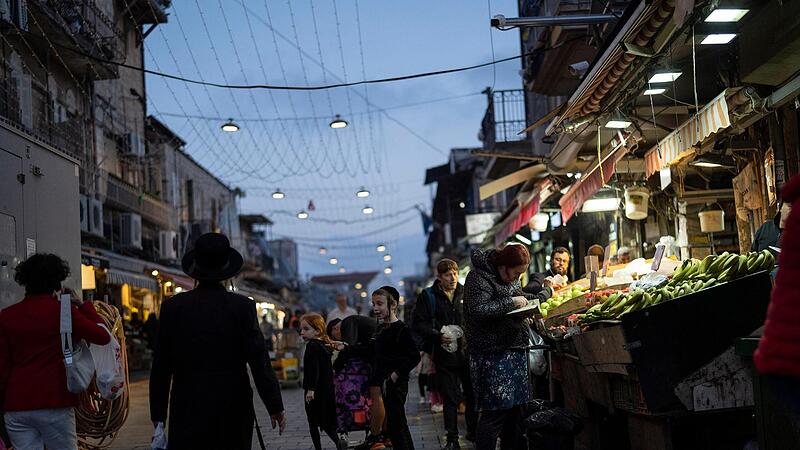 Eine Frau kauft Obst an einem Strand auf dem Mahane Yehuda-Markt. Israel lobte am Sonntagseine Luftabwehr angesichts des Angriffs durch den Iran. Die Systeme hätten 99 Prozent der mehr als 300 Drohnen und Raketen abgewehrt.