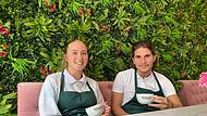 Sally Faust und Matty Behrami gehören zum Personal im neuen „Café 10“ und haben hier kurz Platz genommen vor der imposanten Wiesenwand.