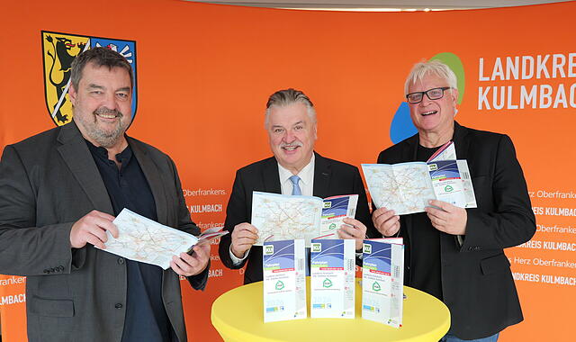 Kompakt und informativ - Volker Griesbach (links) und Michael Beck (rechts) vom Mobilit&auml;ts- und GIS-Management werfen mit Landrat Klaus Peter S&ouml;llner einen Blick in das druckfrische Fahrplanheft des Landkreises f&uuml;r 2026.