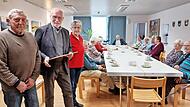 Alfons Galster überbringt beim VG-Café die Anerkennungsurkunde von der Hauptabteilung Seelsorge des Erzbistums an das „Haus der Begegnung“ in Kirchehrenbach als Ort der Hoffnung.