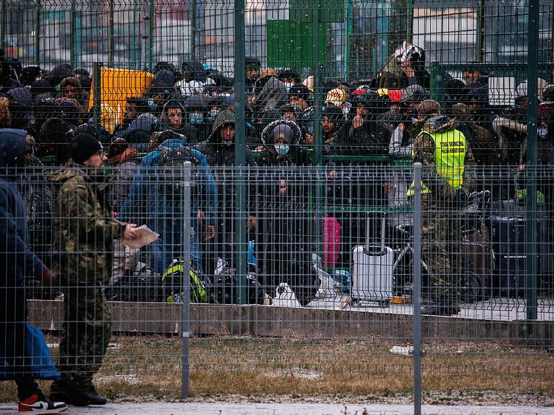 Polen, Medyka: Menschen warten am Grenzübergang hinter einem Tor auf die Einreise nach Polen.
