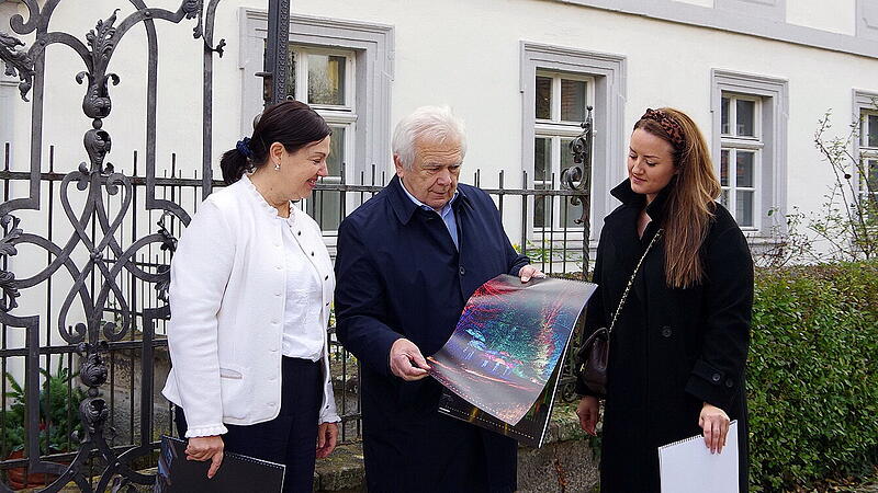 Bürgermeisterin Angela Hofmann, Hartmut Nenninger und die Pressesprecherin der Stadt Kronach, Marina Raithel (v. l.), freuen sich über den Kunstkalender „Kronach leuchtet“ 2026.