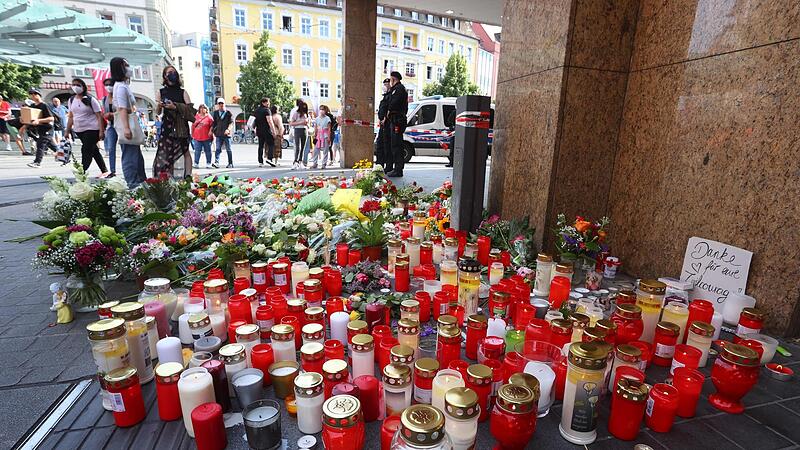 Blumen und Kerzen stellten Passanten nach einer Messerattacke vor das nach der Tat  geschlossenen und abgesperrten Kaufhaus in der W&uuml;rzburger  Innenstadt.