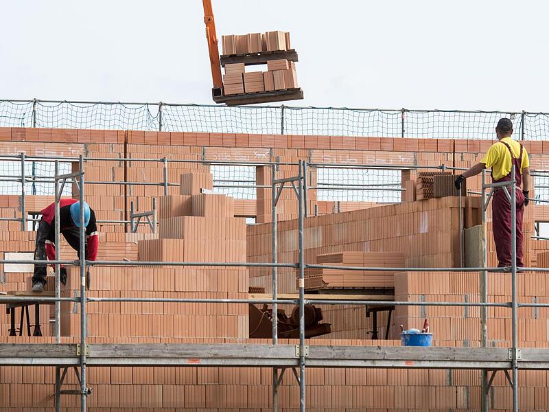 Maurer arbeiten am Bau von Reihenhäusern. Wer seine Immobilie kreditfinanziert, will irgendwann vielleicht wieder aussteigen aus dem Darlehen. Doch das kann teuer werden - nach Ansicht von Verbraucherschützern zu teuer.