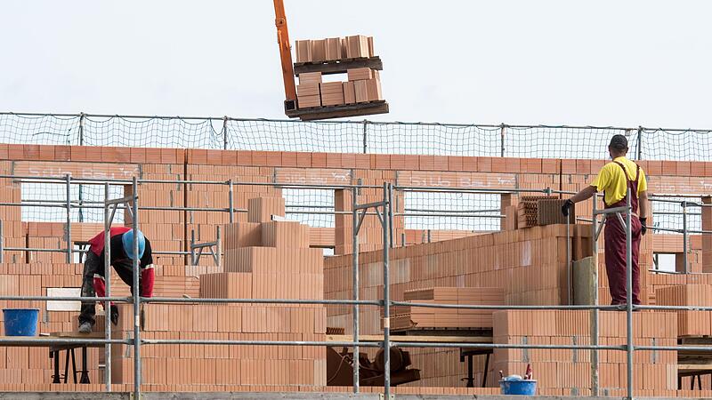 Maurer arbeiten am Bau von Reihenhäusern. Wer seine Immobilie kreditfinanziert, will irgendwann vielleicht wieder aussteigen aus dem Darlehen. Doch das kann teuer werden - nach Ansicht von Verbraucherschützern zu teuer.