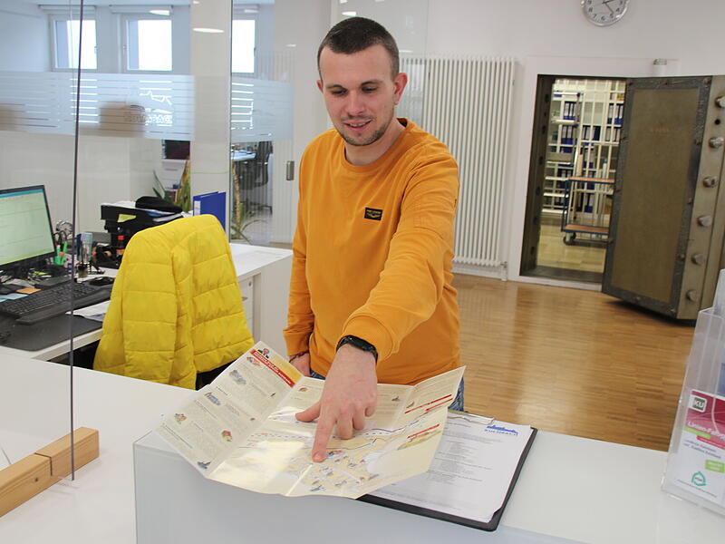 Dominik Weichart arbeitet seit 2009 in der Tourist-Information und leitet diese auch. Hier erkl&auml;rt er gerade den Stadtplan.
