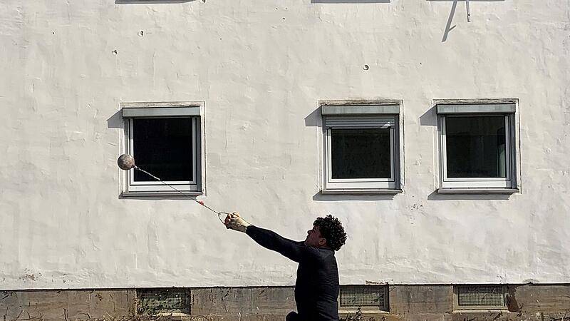 Merlin Hummel schleudert seinen Hammer in Bayreuth gegen die Wand eines Abbruchhauses.